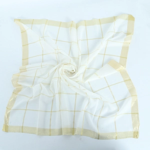 Close-up of translucent white cotton square scarf with golden grid line patterns