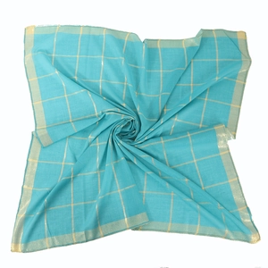 Detailed macro view of lake blue cotton scarf with elegant gold metallic grid pattern