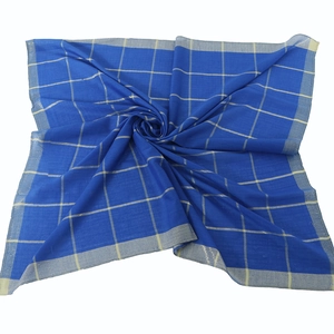 Macro detail of navy plaid cotton scarf with interwoven gold metallic thread and hem