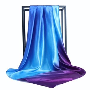 Detail of blue to purple gradient satin square scarf hanging on a minimalist display stand