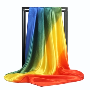 Rainbow gradient silk satin scarf 90x90cm with vibrant colors on a minimalist display