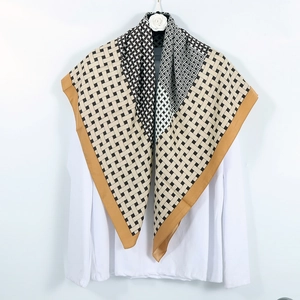 Detail of checkered satin silk scarf in black white and camel styled on a white shirt