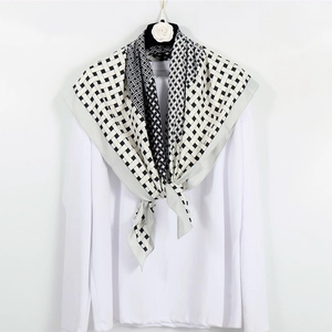 Close-up of black and white geometric pattern on silky 90cm square scarf with a camel decoration