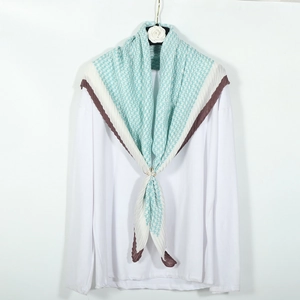 Blue and white houndstooth pleated cotton scarf on a hanger over a white shirt