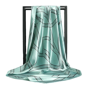 Mint green satin silk scarf with black chain print draped on a square metal frame