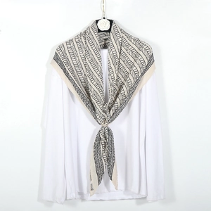 Dettaglio di sciarpa beige geometrica con motivo chevron e trama stropicciata naturale