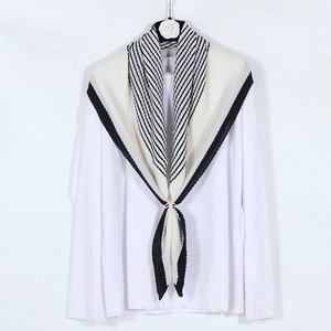 Detail of crinkled cotton linen shawl with monochrome stripes and golden metal ring buckle