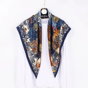 Floral print satin square silk scarf in navy and gold hung on white background