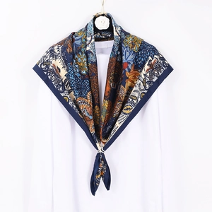 Navy blue tropical print silk scarf styled on a white shirt collar for women