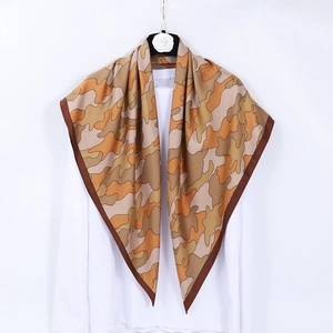 Square camouflage silk scarf in brown and beige with dark borders, hanging display