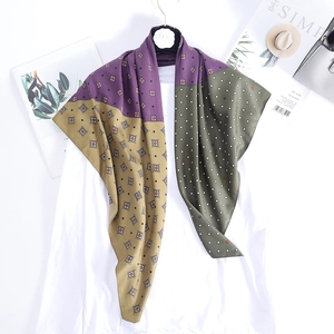 Retro geometric print silk square scarf in purple and green on golden hanger