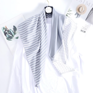 Classic gray and white striped polka dot silk scarf draped over a white shirt