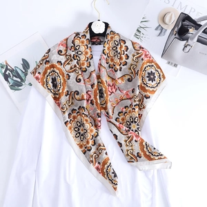 Détails d'un foulard en satin bohème avec motifs géométriques et texture soyeuse drapée