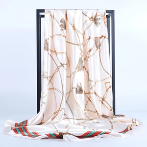 Detailed view of the silk satin square scarf with gold chain print and striped edges