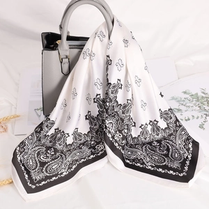 70cm satin silk square scarf with paisley print styled on a grey luxury handbag