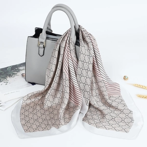 Eleganter 70cm Satinschal mit geometrischen Ringen über einer luxuriösen Handtasche aus Leder