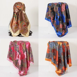 Detail view of four paisley and leopard print satin scarves in assorted vibrant colors