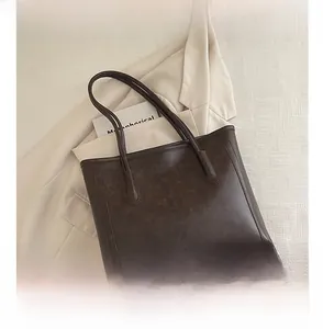 Detailansicht der braunen Vintage-Einkaufstasche mit Handy zum Größenvergleich und Textur