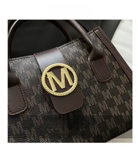 Detailed shot of the golden metal M-logo buckle and dark monogram canvas texture