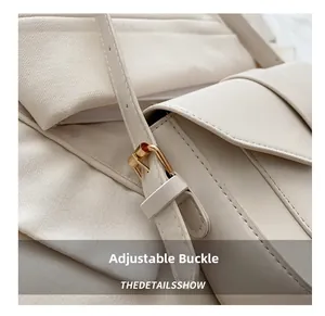 Detail of adjustable golden metal buckle on beige leather shoulder bag strap