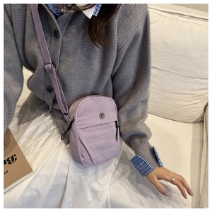 Detail of purple nylon crossbody phone bag with adjustable strap and metal logo