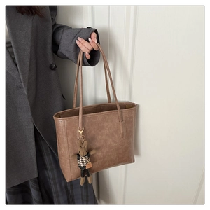 Detailansicht der Vintage braunen Leder-Tragetasche mit einem süßen Plüschhasen-Anhänger