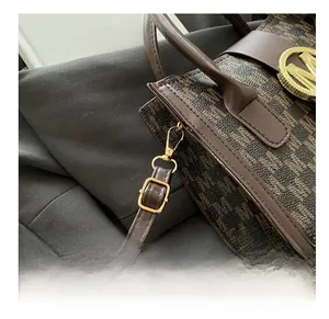 Detail of adjustable shoulder strap with premium golden metal buckle on dark brown bag