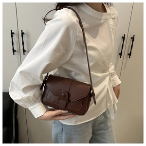 Deep brown matte leather vintage square bag with flap buckle shown on a model
