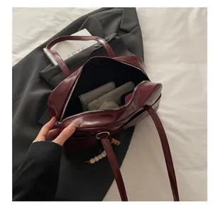 Interior view showing large capacity of the glossy burgundy bowling handbag for storage