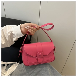 Detail of a bright fuchsia PU leather crossbody bag with a gold buckle and flap closure