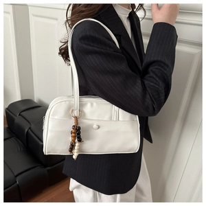 Modern white leather bowling bag with colorful beaded tassel detail and shoulder straps