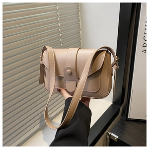 Detail of a beige PU leather crossbody bag with a decorative buckle and strap