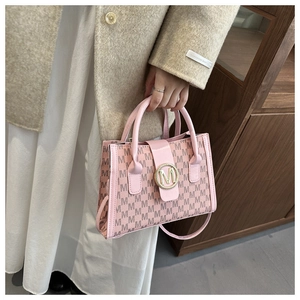 Detail of pink monogram underarm bag with gold M-logo buckle and PU leather texture