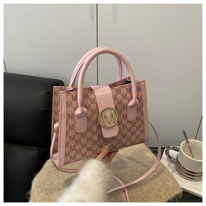 Pink shoulder bag detail showing M-letter print and golden round metallic clasp buckle