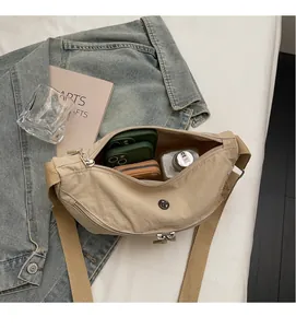 Interior view of beige nylon dumpling bag showing ample space for phone, wallet, and water bottle