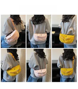 Detail of pink and yellow nylon crossbody bags with adjustable straps and logo