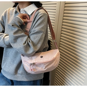 Detail of pink crescent bag showing adjustable strap and durable nylon fabric texture