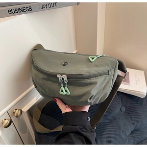 Detail of military green nylon crescent bag with double zippers and triangle pulls