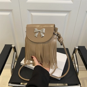 Brown faux patent leather crossbody bag with silver bow buckle and fringe details
