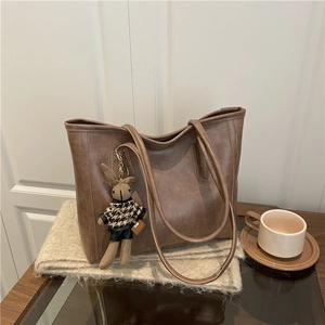 Braune Vintage-Tote-Bag aus PU-Leder mit süßem Hasenanhänger in gemütlicher Szenerie