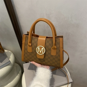 Brown monogram PU leather tote bag with gold M logo and adjustable shoulder strap