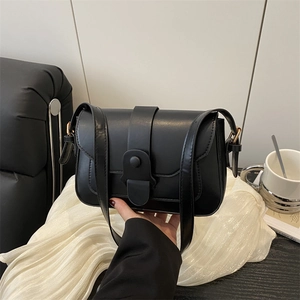 Classic black matte leather crossbody bag with minimalist buckle and gold side accents