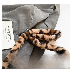 Detailed macro shot of faux fur leopard print strap on a textured grey blazer jacket