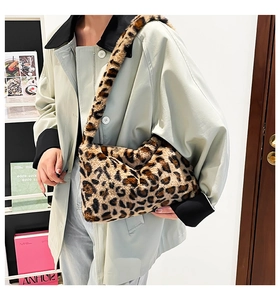 Detail of leopard print faux fur shoulder bag worn with a green trench coat
