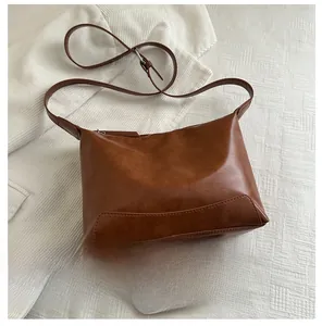 Detail view of deep brown matte leather tote bag size comparison with a smartphone