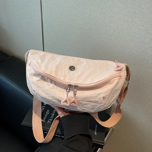 Pink pleated nylon dumpling bag with adjustable shoulder strap and metal logo
