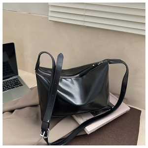 Detail of adjustable strap with silver buckle on a minimalist black leather tote bag