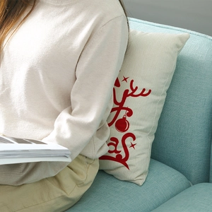 Housse de coussin de Noël avec texte Merry Christmas sur un canapé bleu clair chic