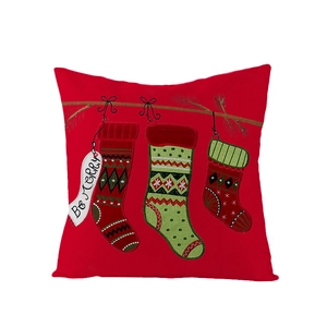 Détail d'une taie d'oreiller de Noël rouge avec trois chaussettes et tag Be Merry
