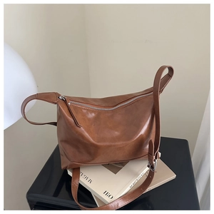 Detailed view of brown PU leather tote bag with silver buckle and adjustable shoulder strap